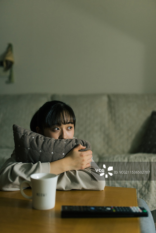 年轻女性在关灯的情况下看电视图片素材