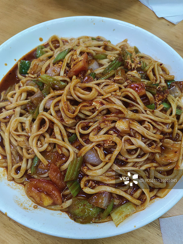 桌上盘子里的陕西特色西红柿鸡蛋炒拉条面条特写镜头图片素材