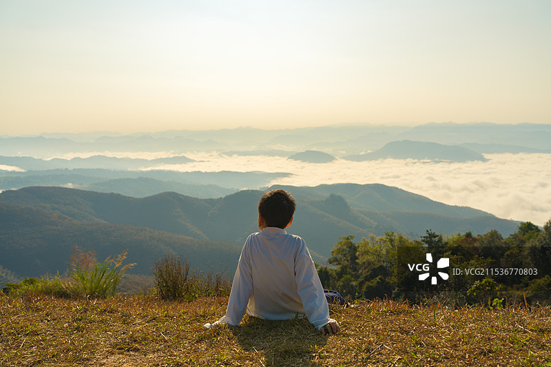 男孩背靠天空看云海的背影图片素材