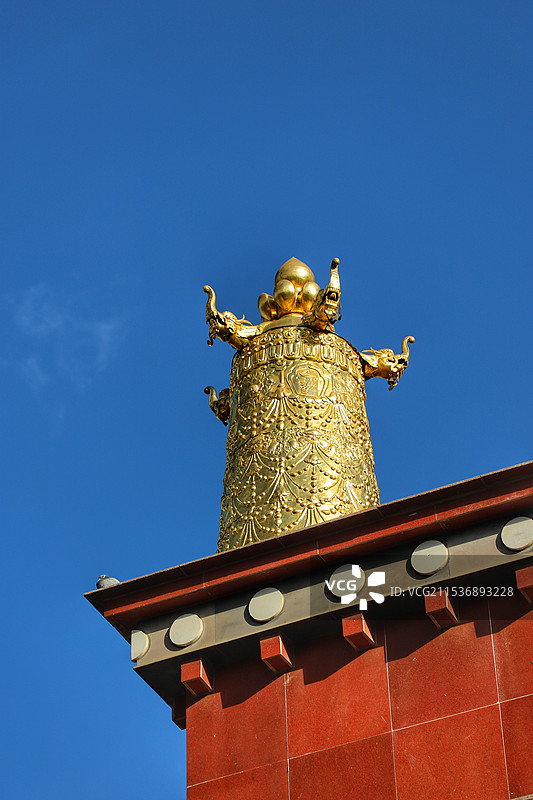 蓝天下藏式寺庙顶的金色经筒图片素材