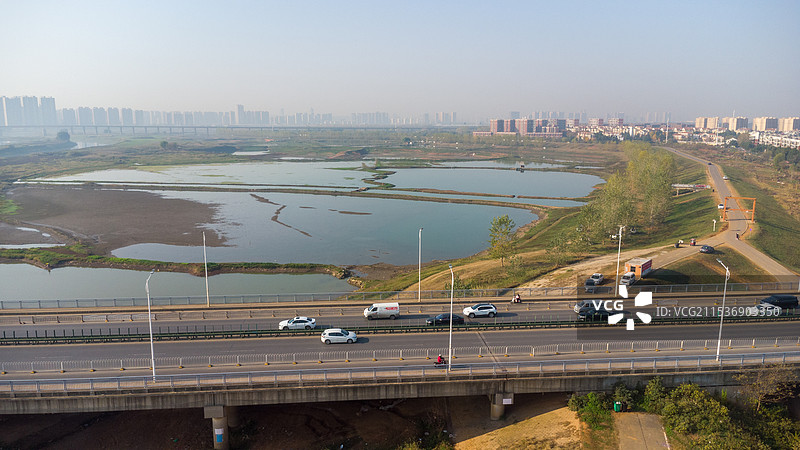 航拍：武汉汉口北盘龙城盘龙桥与城市天际线和金融商务服务交通概念背景图图片素材