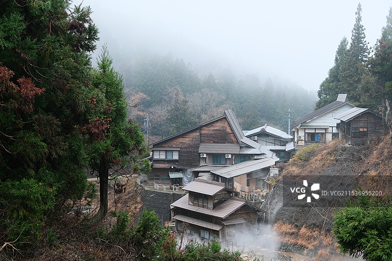 日本长野县地狱谷野猿公苑云雾中的房屋与森林图片素材