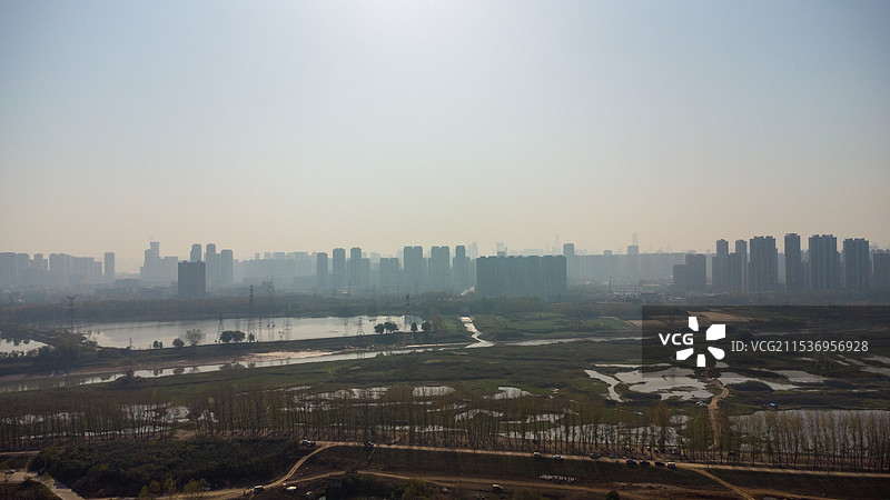 航拍：武汉府河湿地公园早晨雾气中蓝色湖泊天空建筑城市天际线和自然风光生活健身生态保护概念背景图图片素材