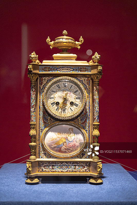 红色背景下的铜镀金珐琅钟图片素材