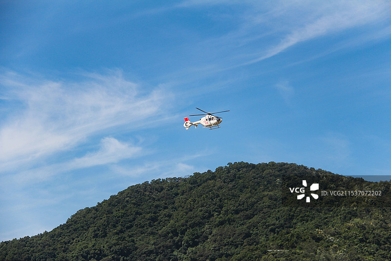 直升机在蓝天下飞行的低角度视图图片素材