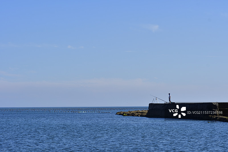海岸边正在钓鱼的人图片素材