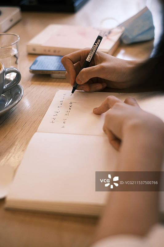 在桌子上写字的女人的手图片素材