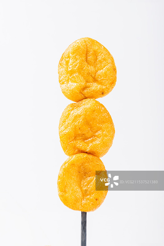 筷子串着三个罗定皱纱鱼腐，油炸肉丸，传统美食图片素材