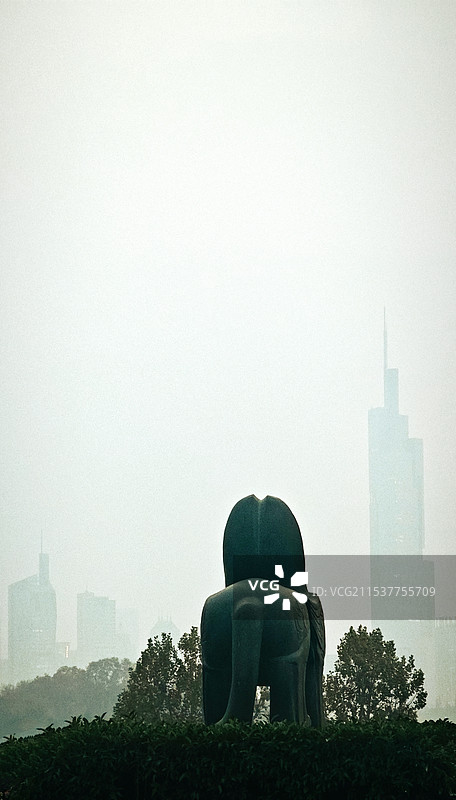 雾色背景中的南京站石狮子与紫峰大厦城市建筑景观图片素材