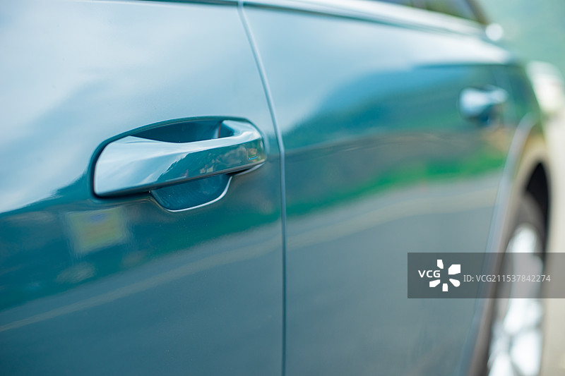 中国新能源汽车拍摄主题，汽车上的门把手的喷漆油漆反射效果，户外白昼无人图像摄影图片素材
