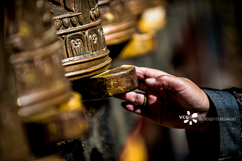 一只正在拨弄转经筒的手图片素材