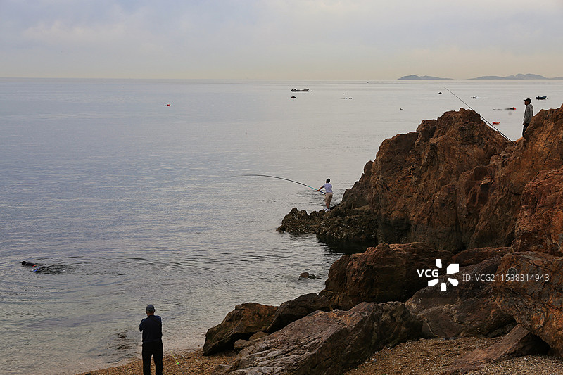 大连海边礁石上的垂钓者图片素材