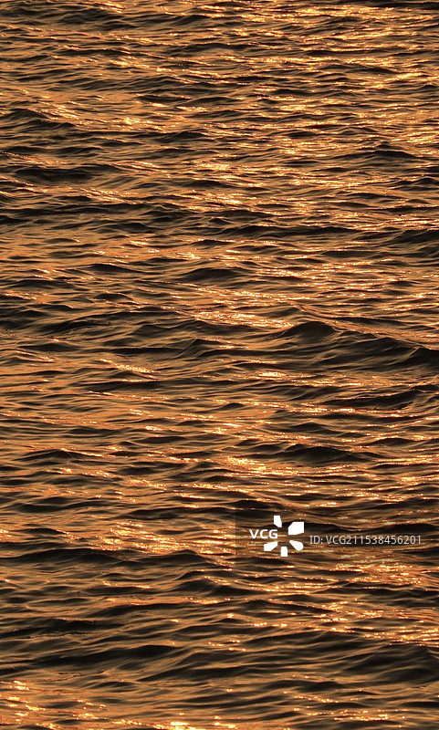 夕阳下橘色海面波光粼粼波纹图片素材