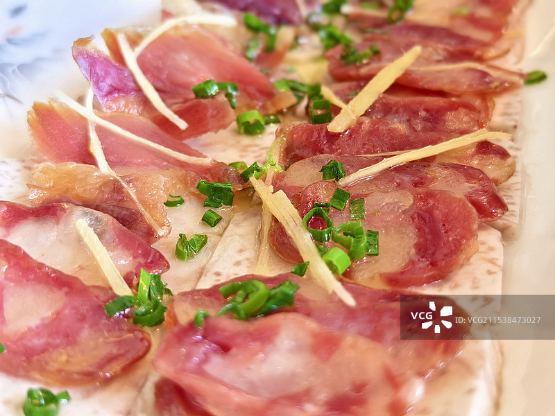 粤式腊味蒸芋头。新鲜香甜的芋头薄切，配上偏咸的腊肠腊肉，加上一点提鲜的葱花和姜丝，是一道传统的粤菜图片素材