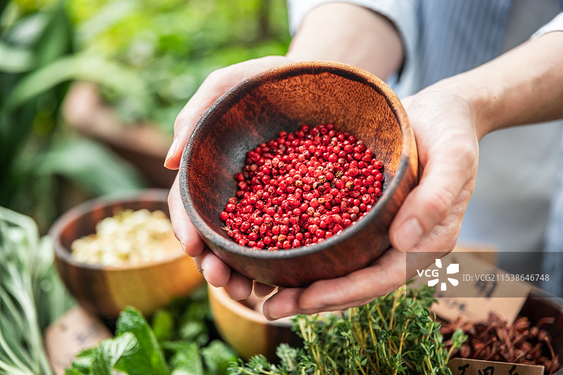 手拿着装有红胡椒的碗图片素材
