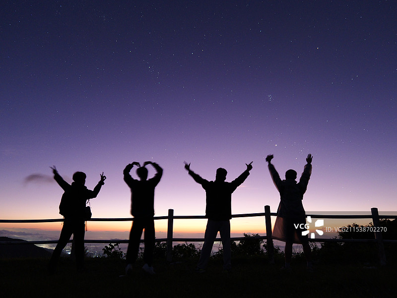 夕阳下人们在天空中跳跃的剪影图片素材