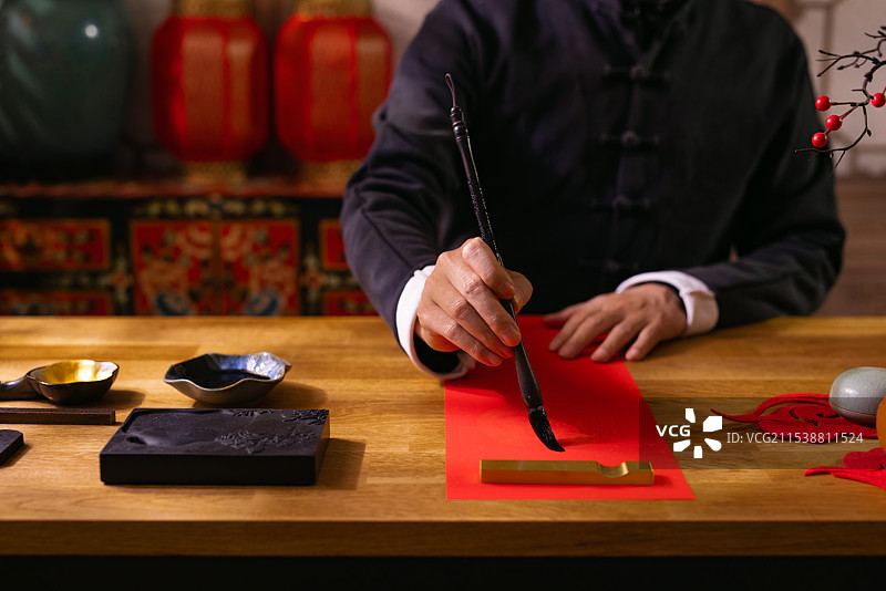 一个东方人在书房里写春联图片素材