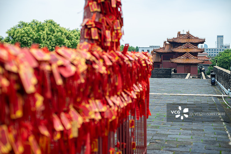 中国传统文化和自然风光拍摄主题  ,栏杆上悬挂着大量红色许愿牌子和远处的角楼，户外白昼无人图像摄影图片素材