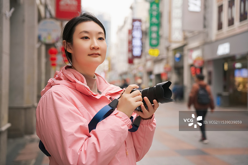迷人的街头摄影：一位年轻女子捕捉城市瞬间图片素材
