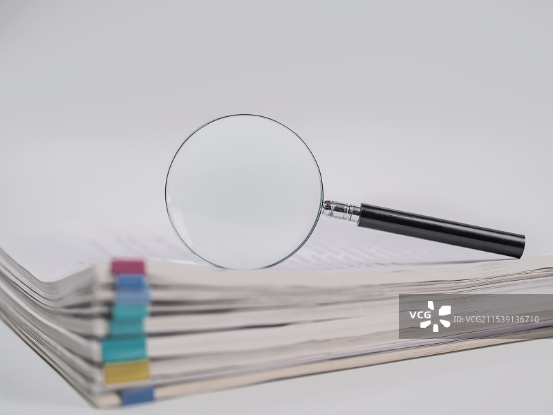 放大镜、纸质文件资料与白色背景留白图片素材