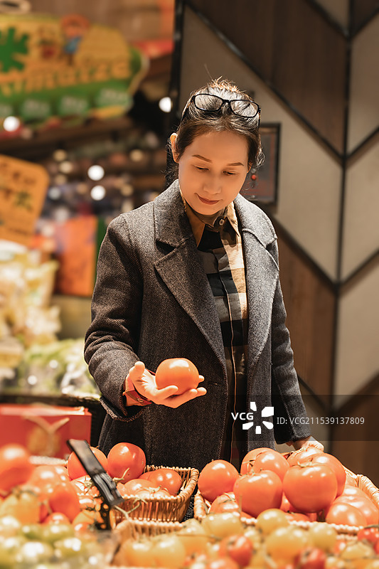 城市购物者在现代超市选购新鲜蔬菜图片素材