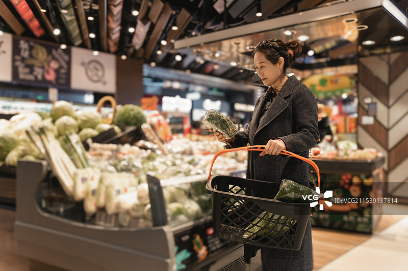 城市购物者在现代超市选购新鲜蔬菜图片素材