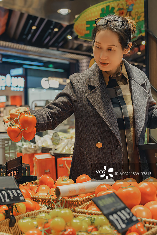 城市购物者在现代超市选购新鲜蔬菜图片素材