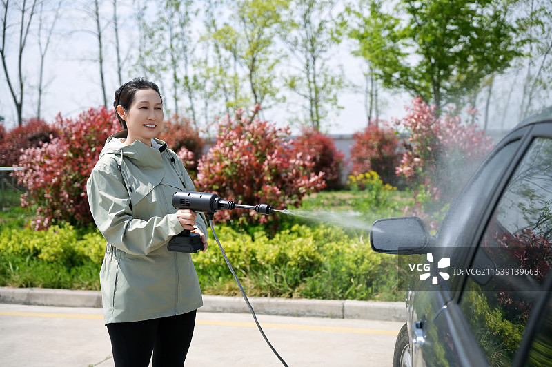 女人喜欢用便携式净水器洗车图片素材