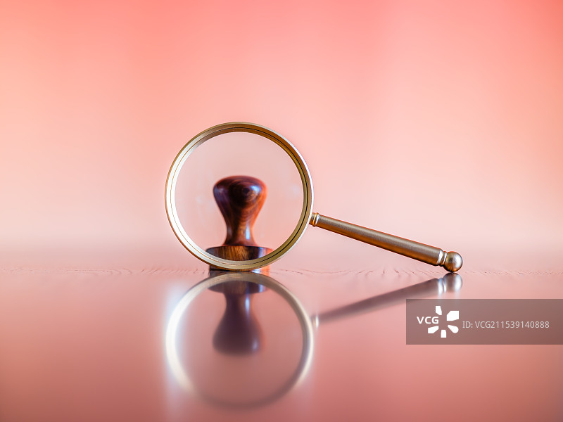 放大镜、木制印章与橙红色背景留白图片素材