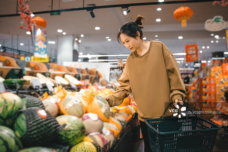 年轻女子在充满活力的市场中探索新鲜农产品图片素材