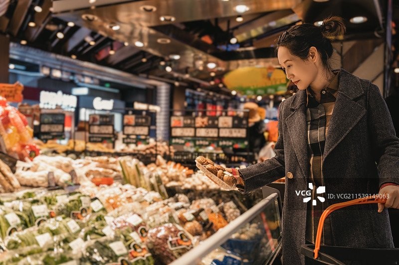女人在现代杂货店买新鲜蔬菜图片素材