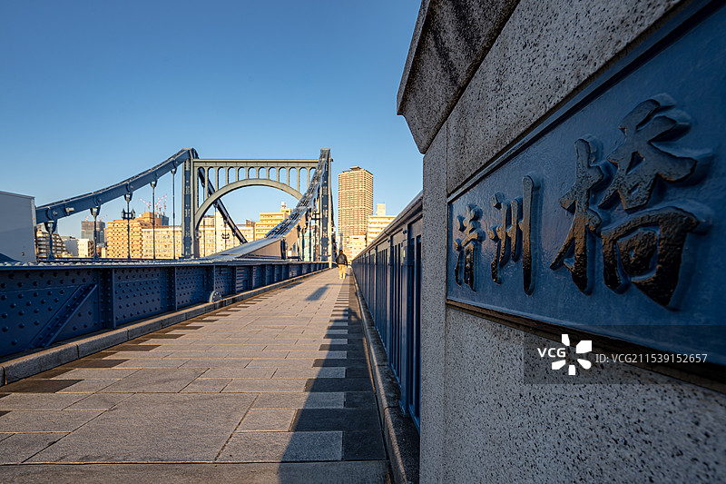 清晨阳光照亮河道上的钢架大桥，日本东京图片素材