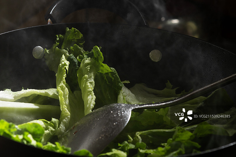 正在锅子中烹饪的绿色蔬菜图片素材