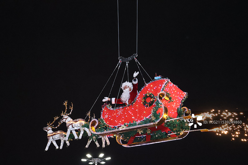 海南海口圣诞节平安夜糖果红色圣诞树圣诞氛围圣诞飞雪人造雪圣诞老人飞过城市上空图片素材