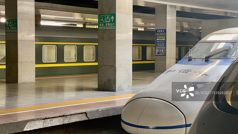 近景的高铁与远处的绿皮火车图片素材