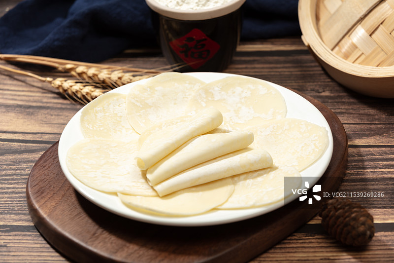 厚木板上摆放着一盘饺子皮图片素材