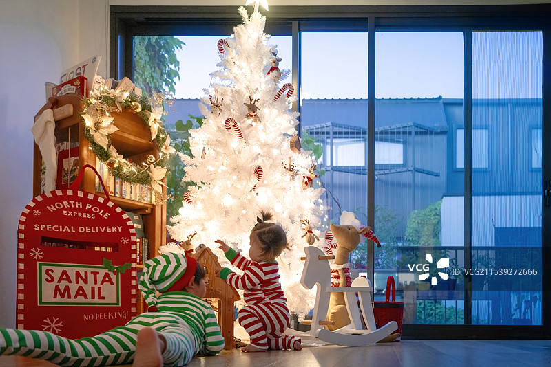 圣诞平安夜中的快乐小男孩与女婴妹妹图片素材