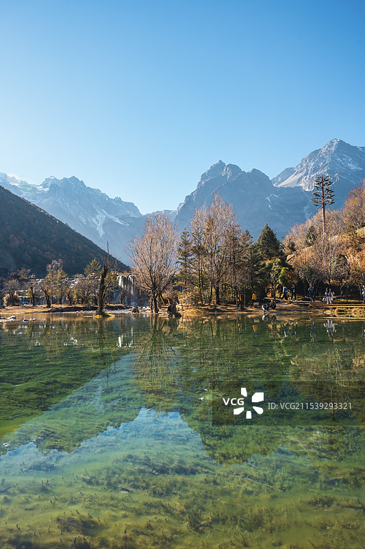 云南玉龙雪山下的蓝月谷景区，人间仙境，湖泊宁静如镜，树木山脉倒映其中，游客悠然享受美好。图片素材