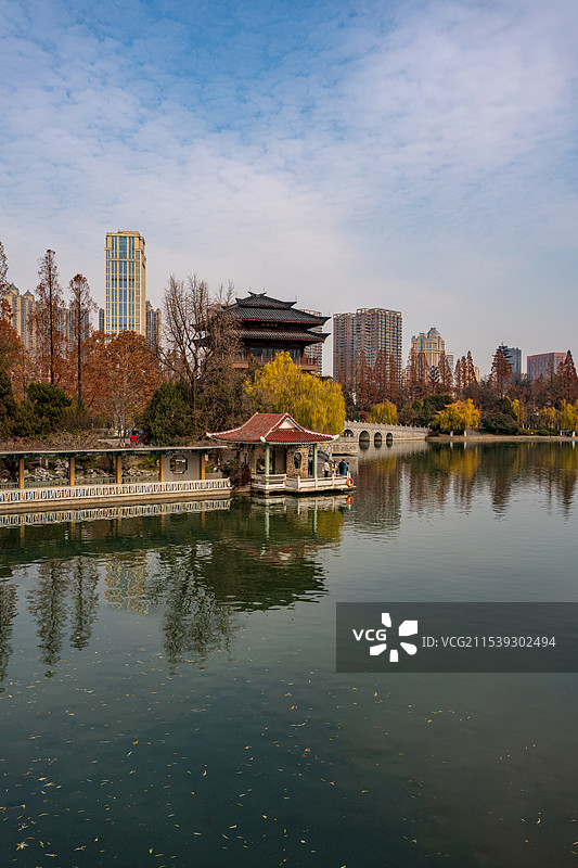 竖拍逍遥津公园内的逍遥湖与远处的住宅楼图片素材