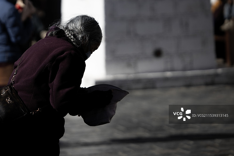 正在朝寺庙方向鞠躬的老人图片素材