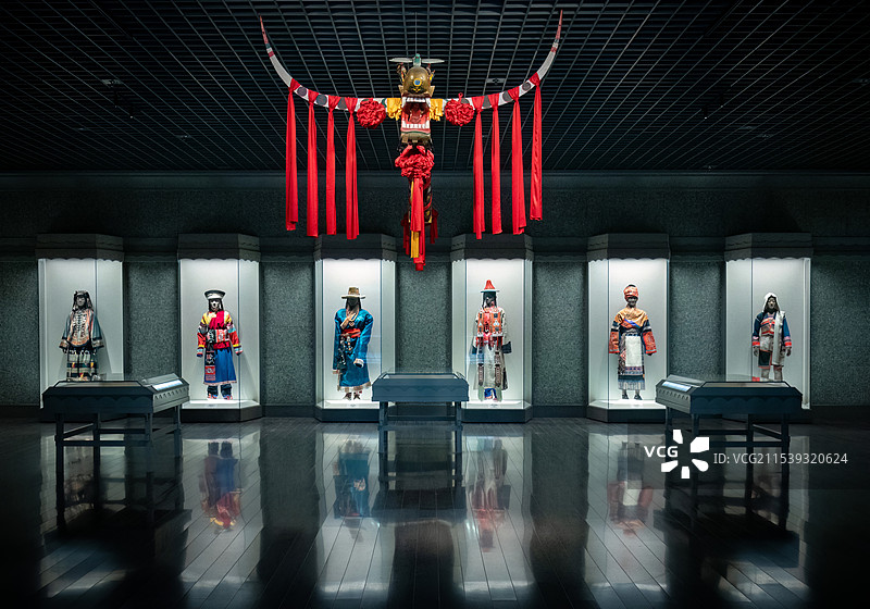 上海博物馆内展示一角，中国传统民族服饰展，牛角上挂着红色绳子图片素材
