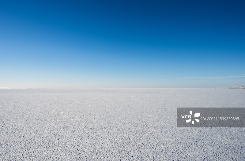 冬季冰冻的湖面与纯净的蓝色天空图片素材