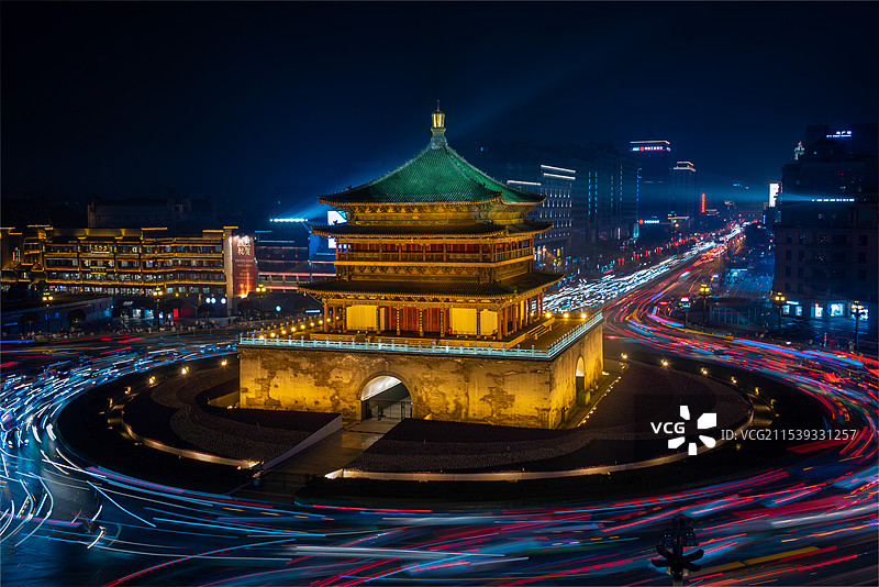 夜色下的陕西西安古都，古色古香的钟楼被夜景灯光照亮，车流环绕钟楼流过形成车轨，繁华古都图片素材