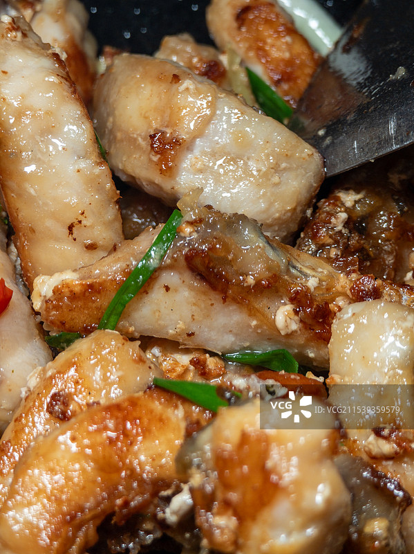 铁锅中香煎金黄的脆肉鲩鱼片图片素材