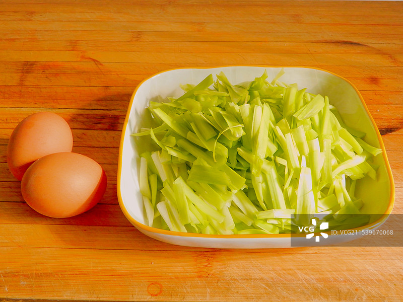 厨房菜板上的鸡蛋和盘子里切好的韭黄图片素材