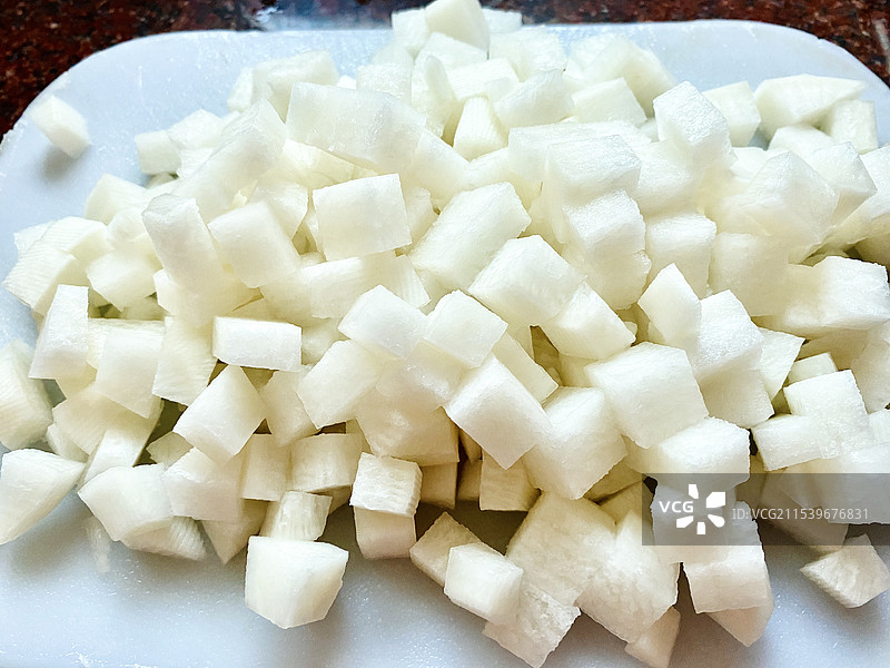 白色刀板上萝卜粒萝卜丁的特写图片素材