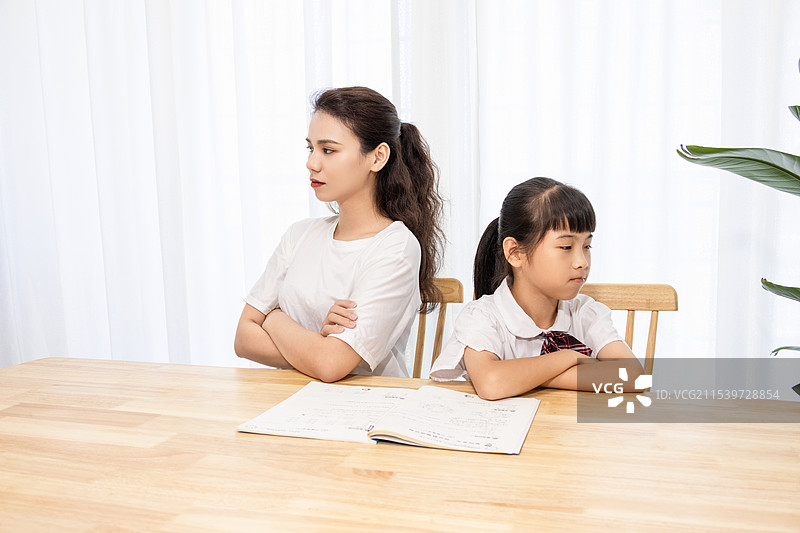 一名妈妈辅导孩子写作业时很苦恼图片素材