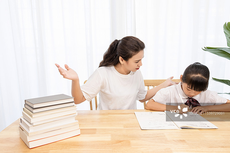 一名妈妈辅导孩子写作业时很苦恼图片素材