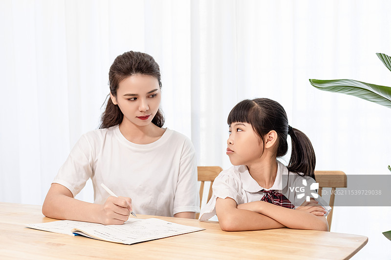 一名妈妈辅导孩子写作业时很苦恼图片素材