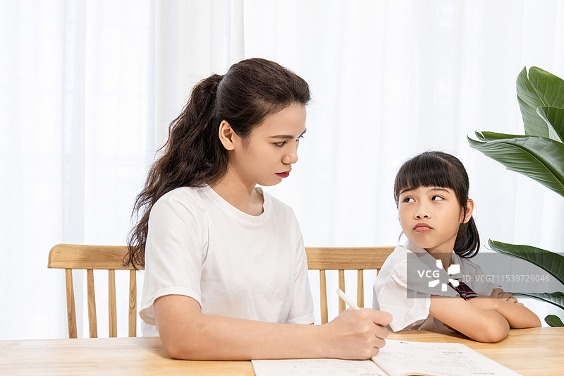 一名妈妈辅导孩子写作业时很苦恼图片素材